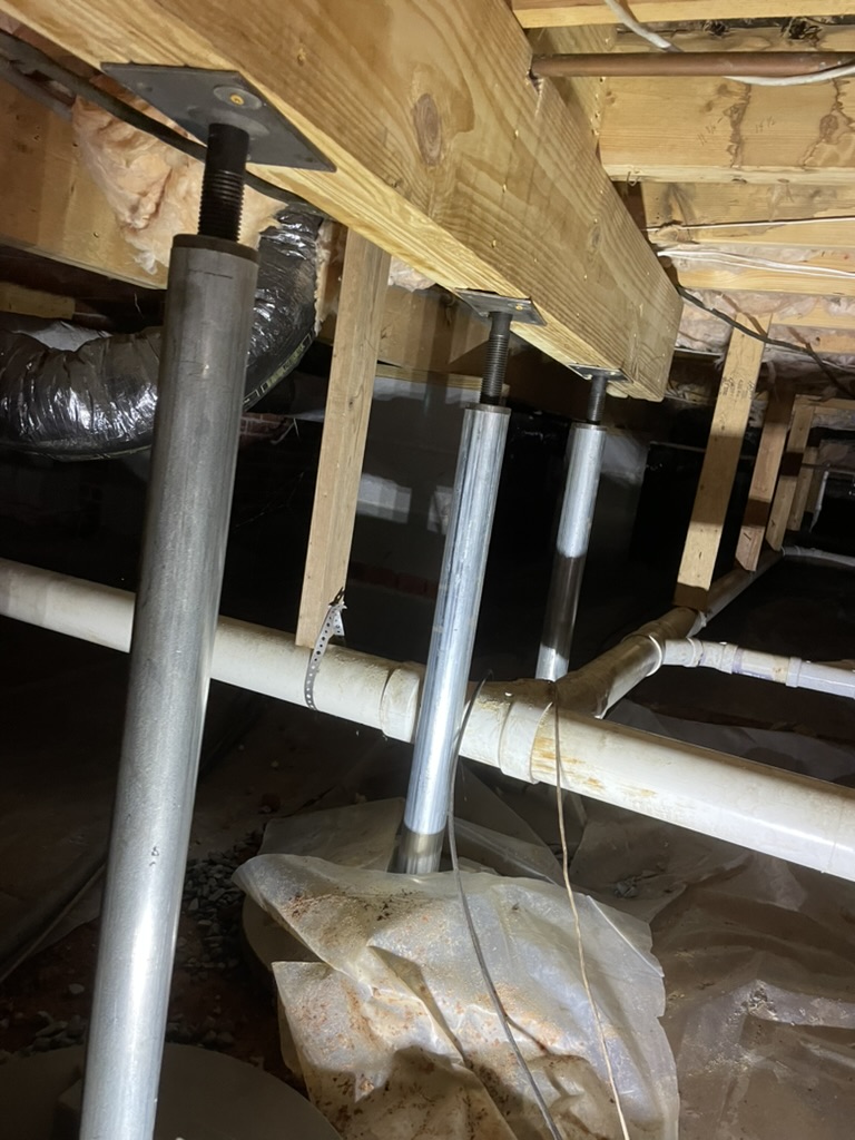 Adjustable steel post jacks on a beam in an Western North Carolina Crawlspace